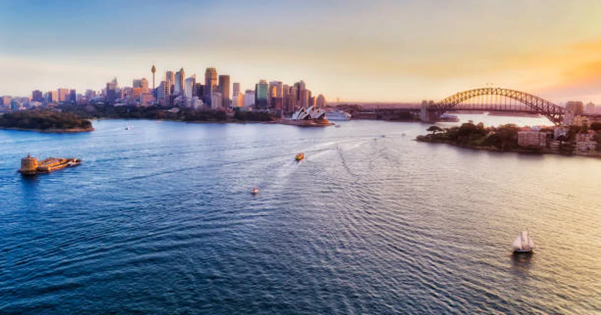 Aerial view of Sydney harbour and CBD at twilight with city lights glowing